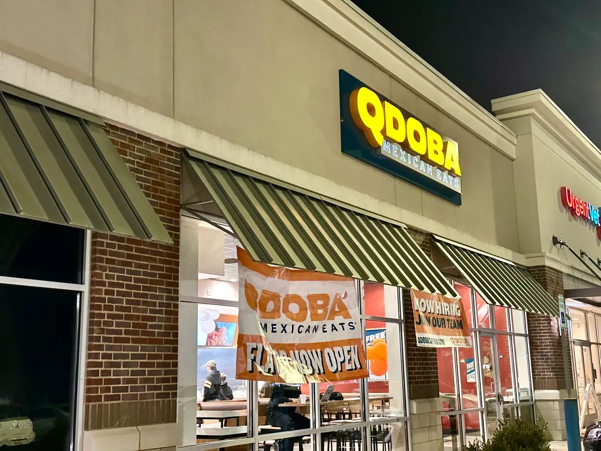 The Qdoba in Hoover, Alabama, at night, with a Now Hiring banner in the window